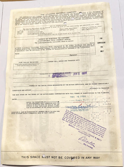 Vintage 1960s Atlantic Refining Company stock certificate with blue ink stamps and handwritten signatures on aged cream paper