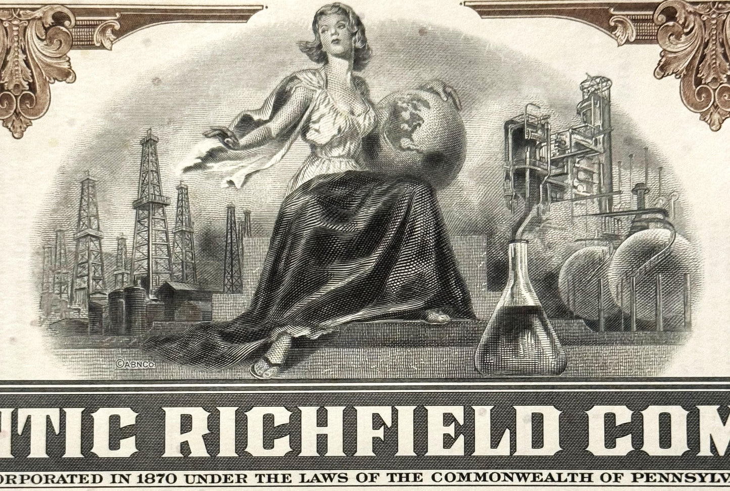 Vintage engraved stock certificate with allegorical female figure and industrial oil derricks, ornate borders, brown ink on c
