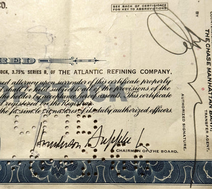 Vintage stock certificate from Atlantic Refining Company with printed text, decorative blue border, handwritten signature, an