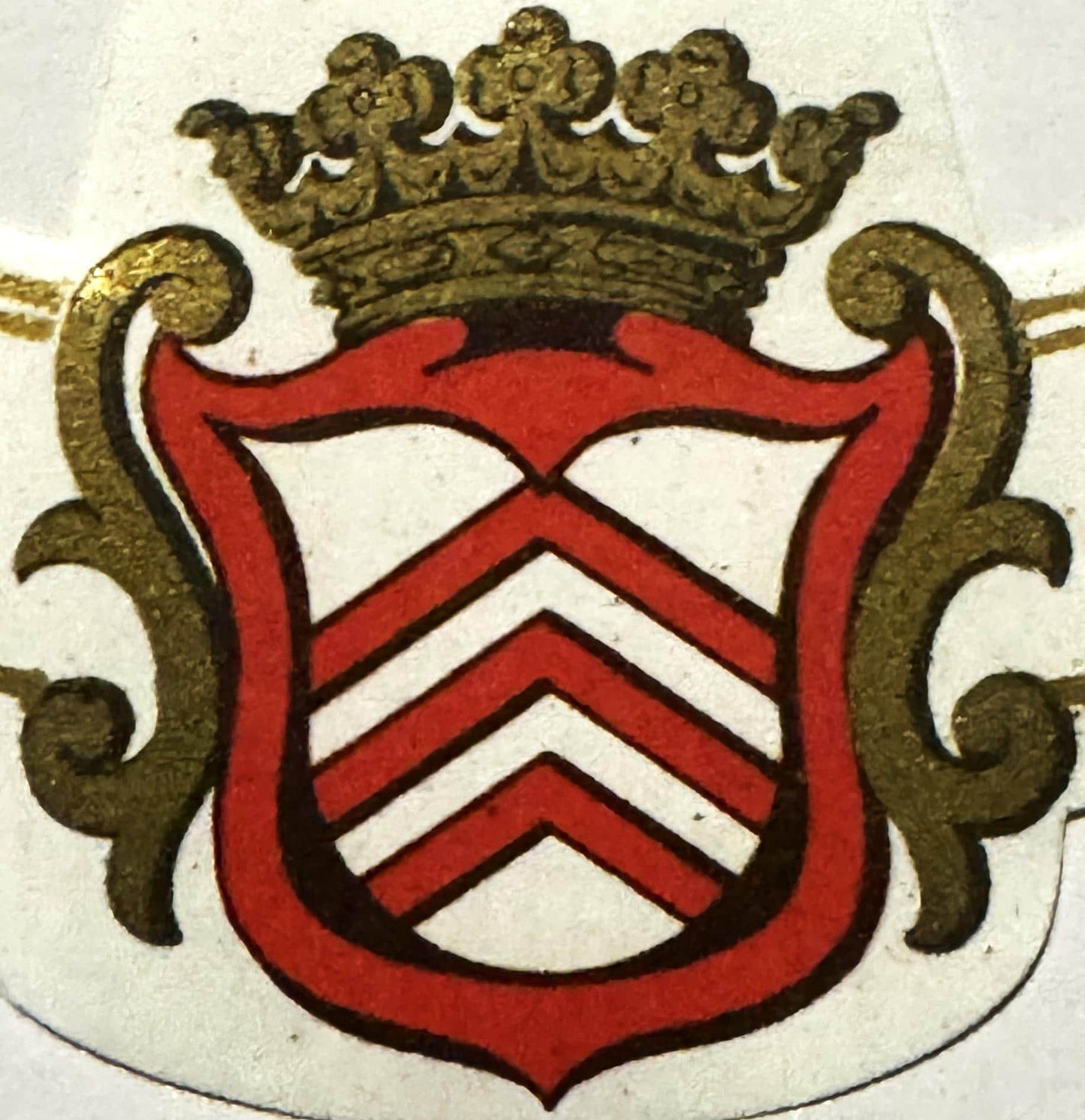Antique French wine label with red chevron stripes on shield, gold crown, and ornamental scrollwork on cream background