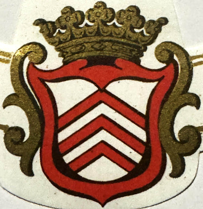 Antique French wine label with red chevron stripes on shield, gold crown, and ornamental scrollwork on cream background