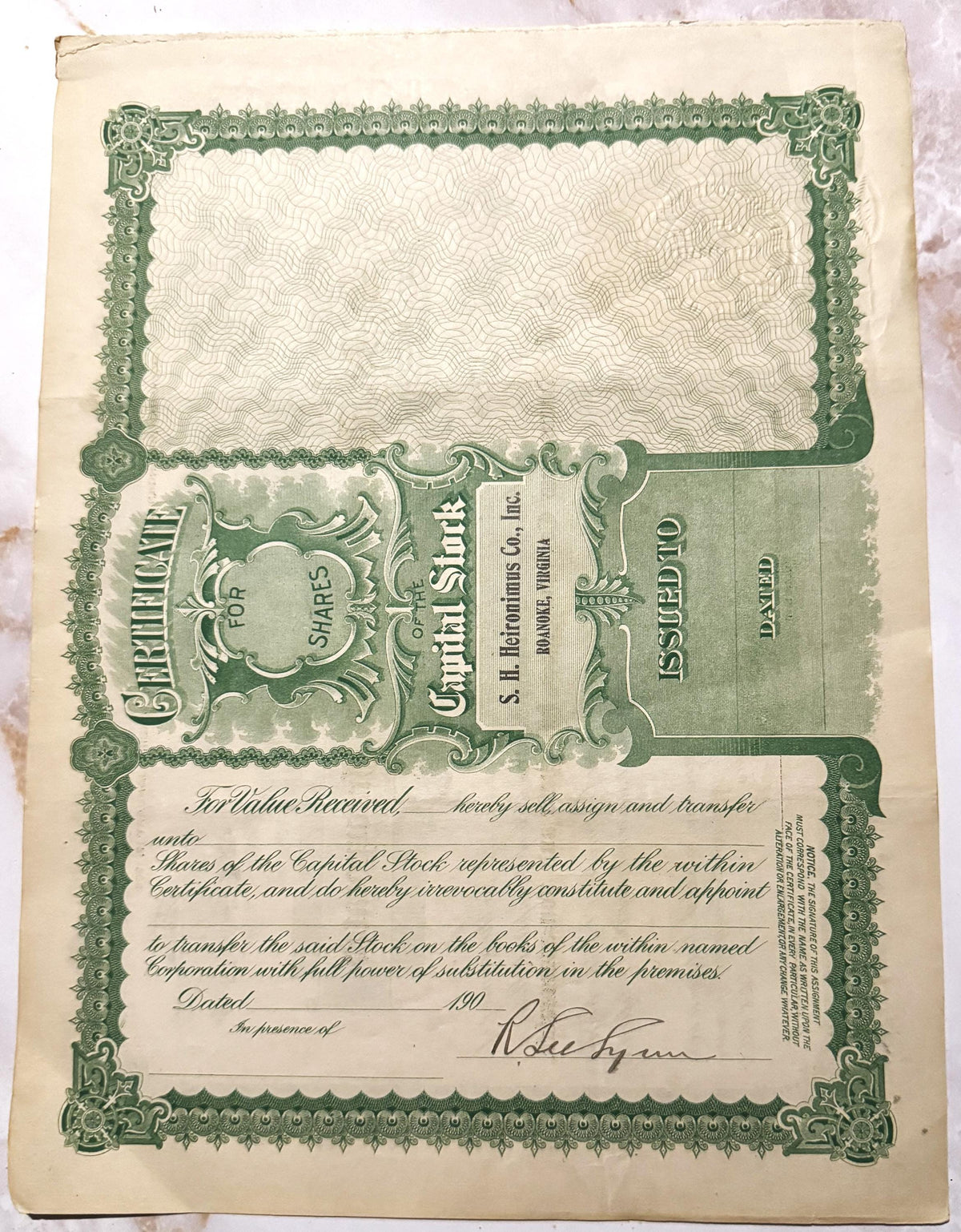 Antique stock certificate with ornate green border and decorative frame, for S.H. Heironimus company, printed on