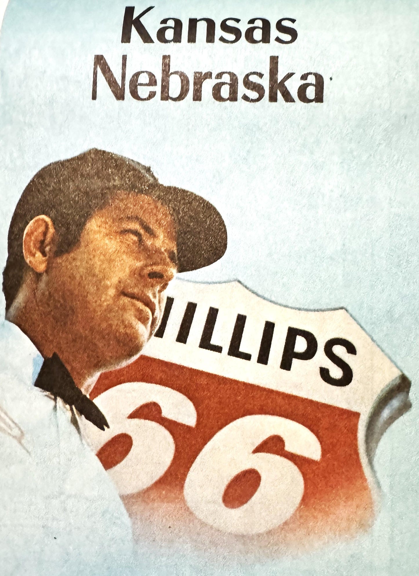 Vintage Phillips 66 map cover featuring a cowboy in profile wearing a black hat on cream and red shield with "PHILLIPS 66" an