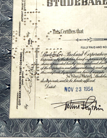 Vintage stock certificate for Studebaker-Packard Corporation, featuring ornate border, blue ink stamp
