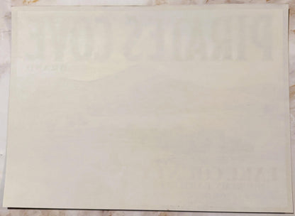 Blank cream-colored vintage fruit crate label with faint watermark, photographed flat against textured surface