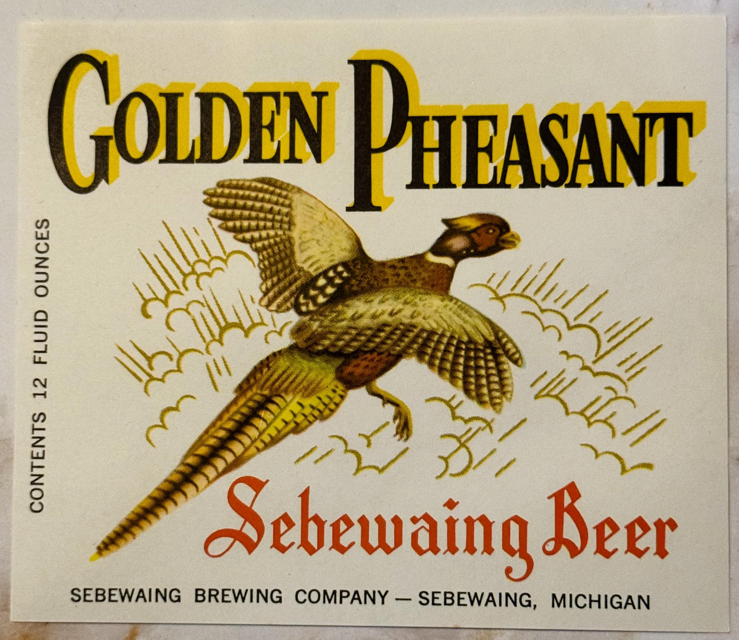 Vintage beer label featuring golden pheasant in flight with "Golden Pheasant Sebewaing Beer" text and Sebewaing Brewing Compa