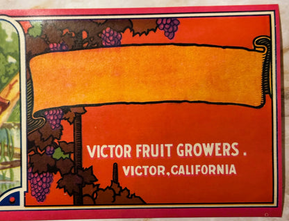 Vintage fruit crate label with orange banner, purple grapes, and text "Victor Fruit Growers, Victor, California" on red backg