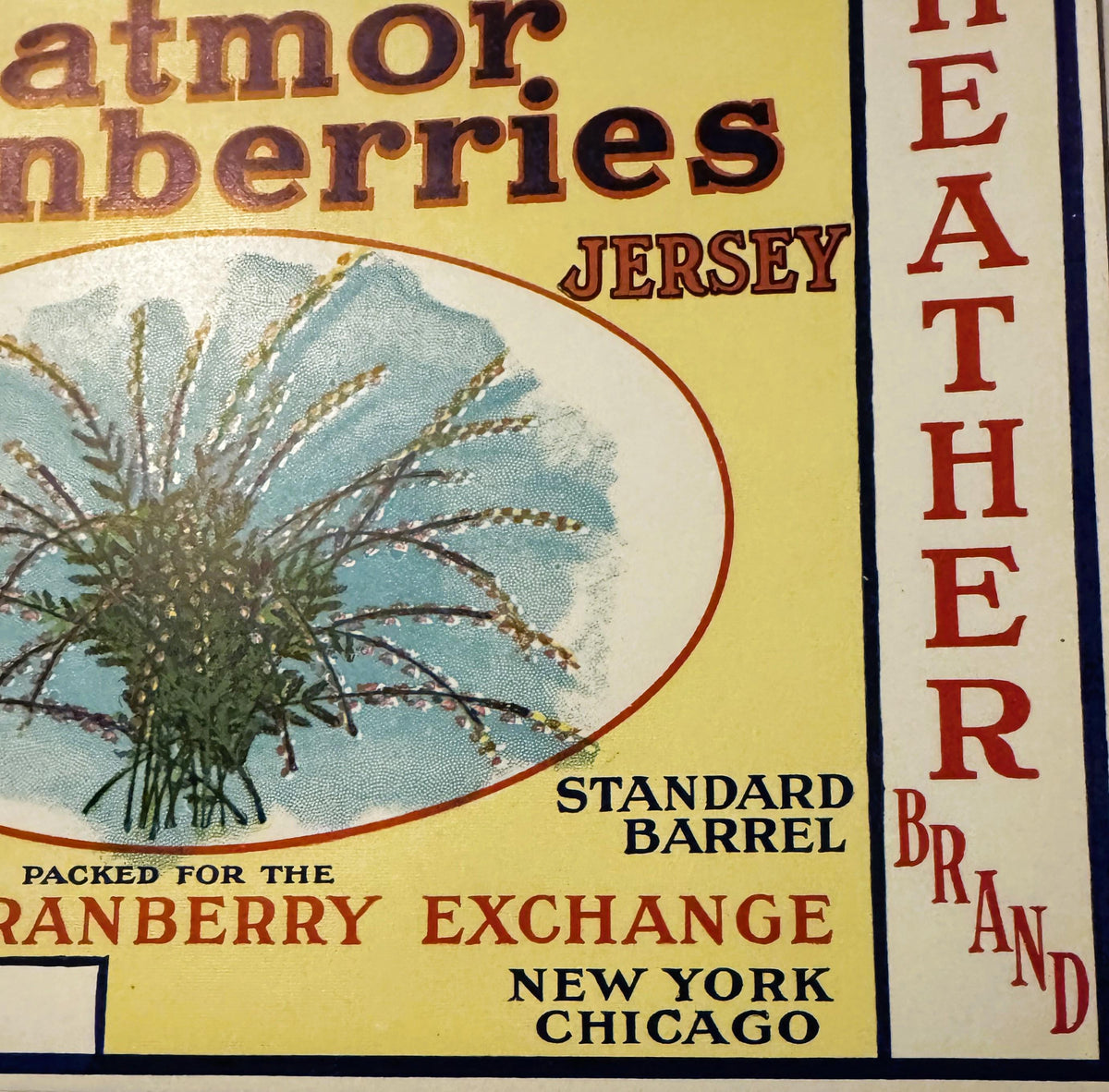 Vintage cranberry barrel label with yellow background, illustrated thistle plant, text reading "Eatmor Cranberries Jersey," "