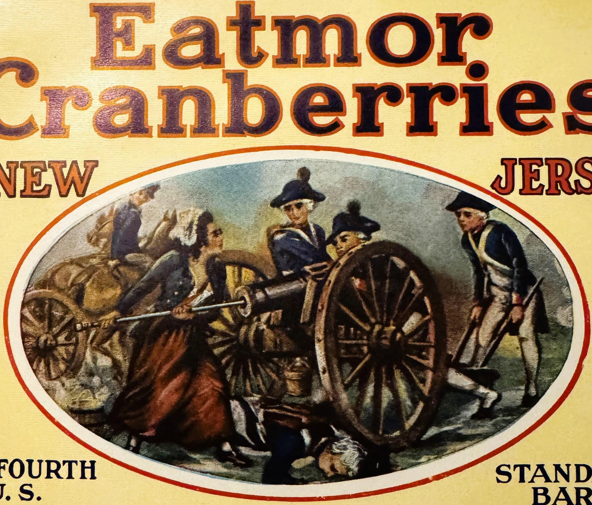 Vintage Eatmor Cranberries barrel label with red and gold text, featuring colonial soldiers with a cannon in an oval illustra