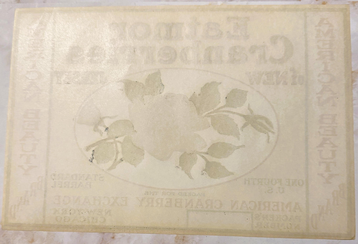 Faded cream-colored vintage cranberry barrel label with oval botanical illustration of leaves and berries, embossed text part
