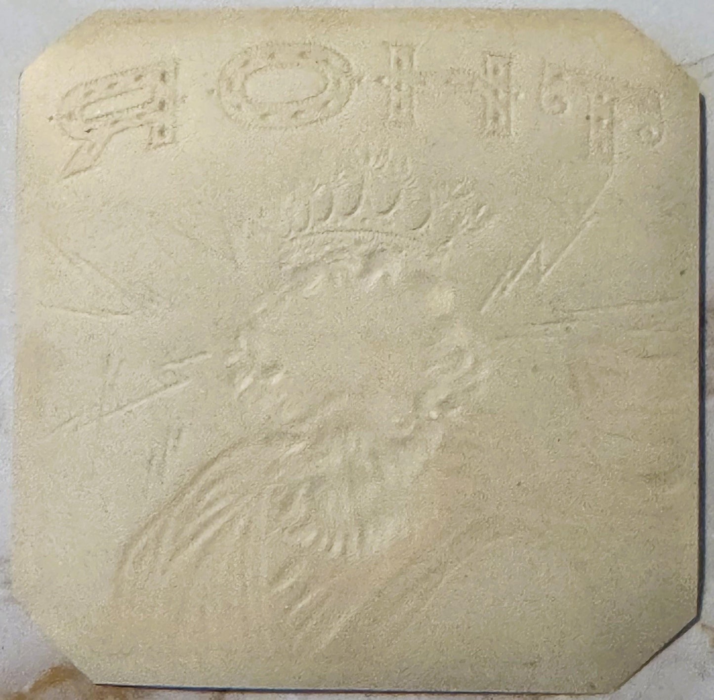 Cream-colored embossed stone or plaster tile featuring Thor's bearded face and upper body in relief, with decorative text at 