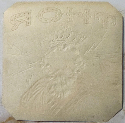 Cream-colored embossed stone or plaster tile featuring Thor's bearded face and upper body in relief, with decorative text at 