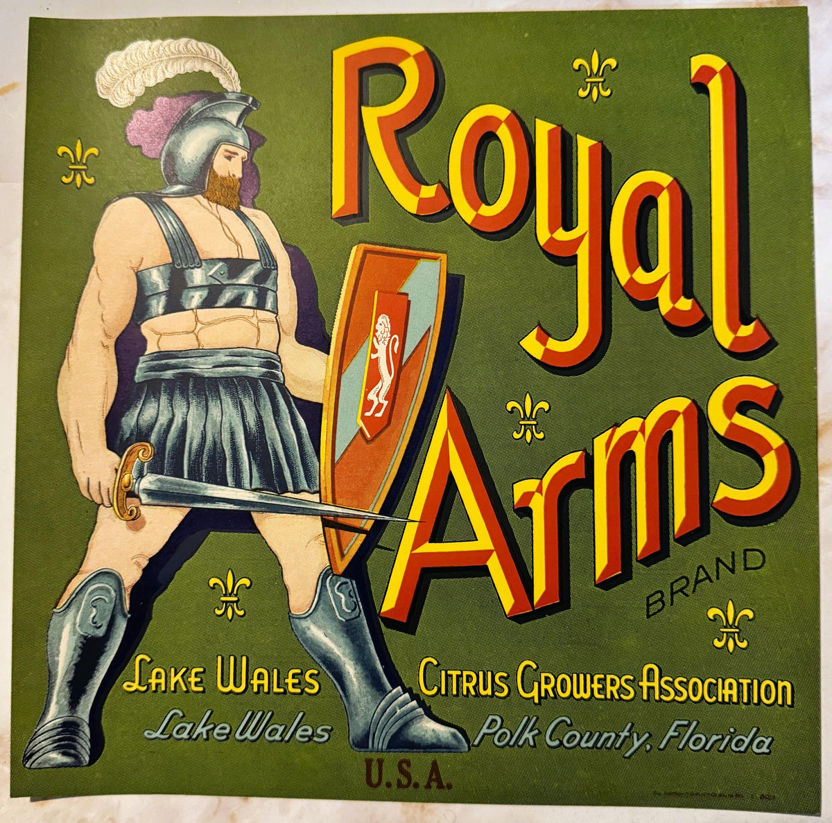 Vintage citrus crate label featuring a bearded warrior in Roman armor holding a shield, bold yellow and red "Royal Arms" text