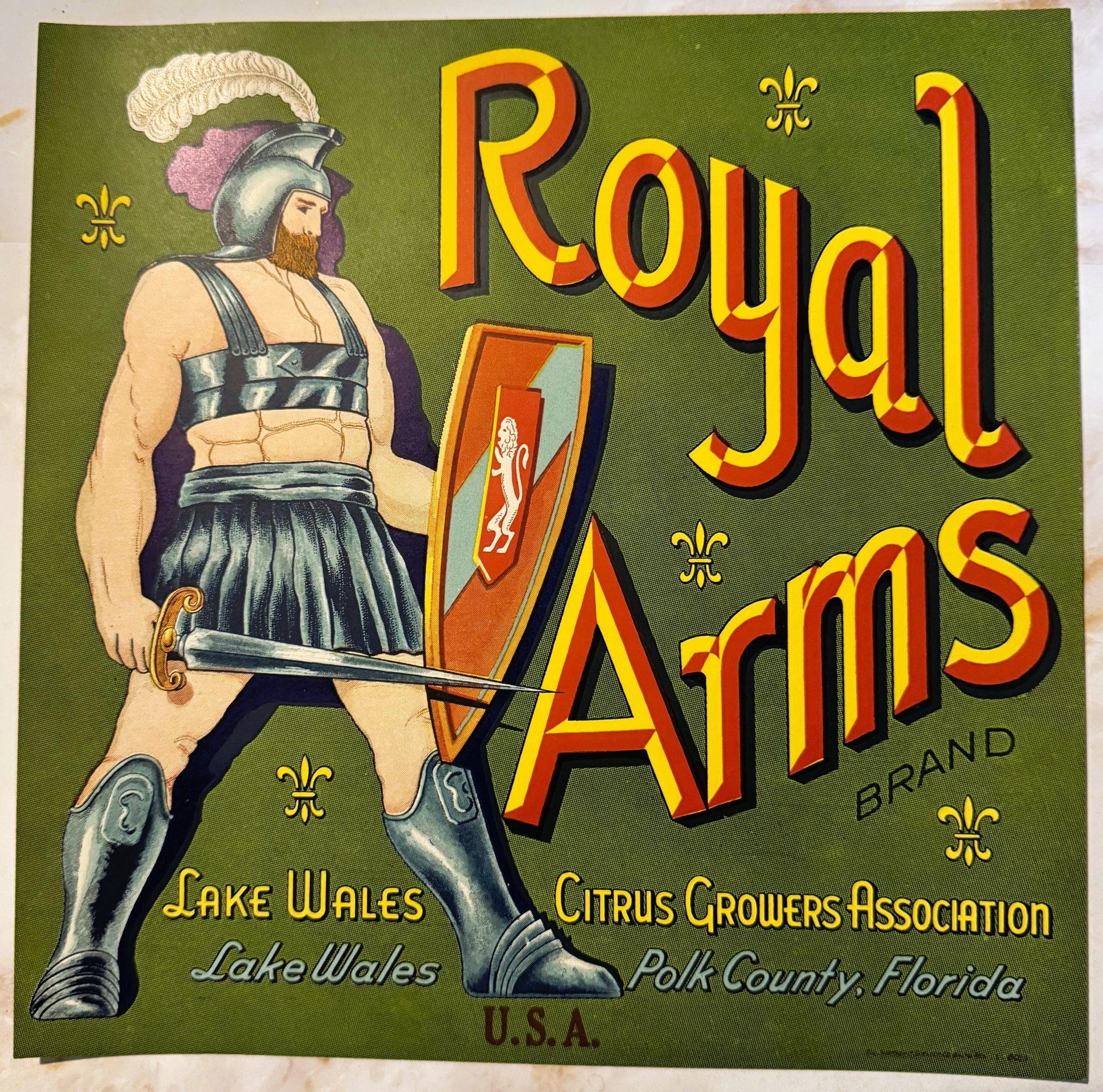 Vintage citrus crate label featuring a bearded warrior in Roman armor holding a shield, bold yellow and red "Royal Arms" text