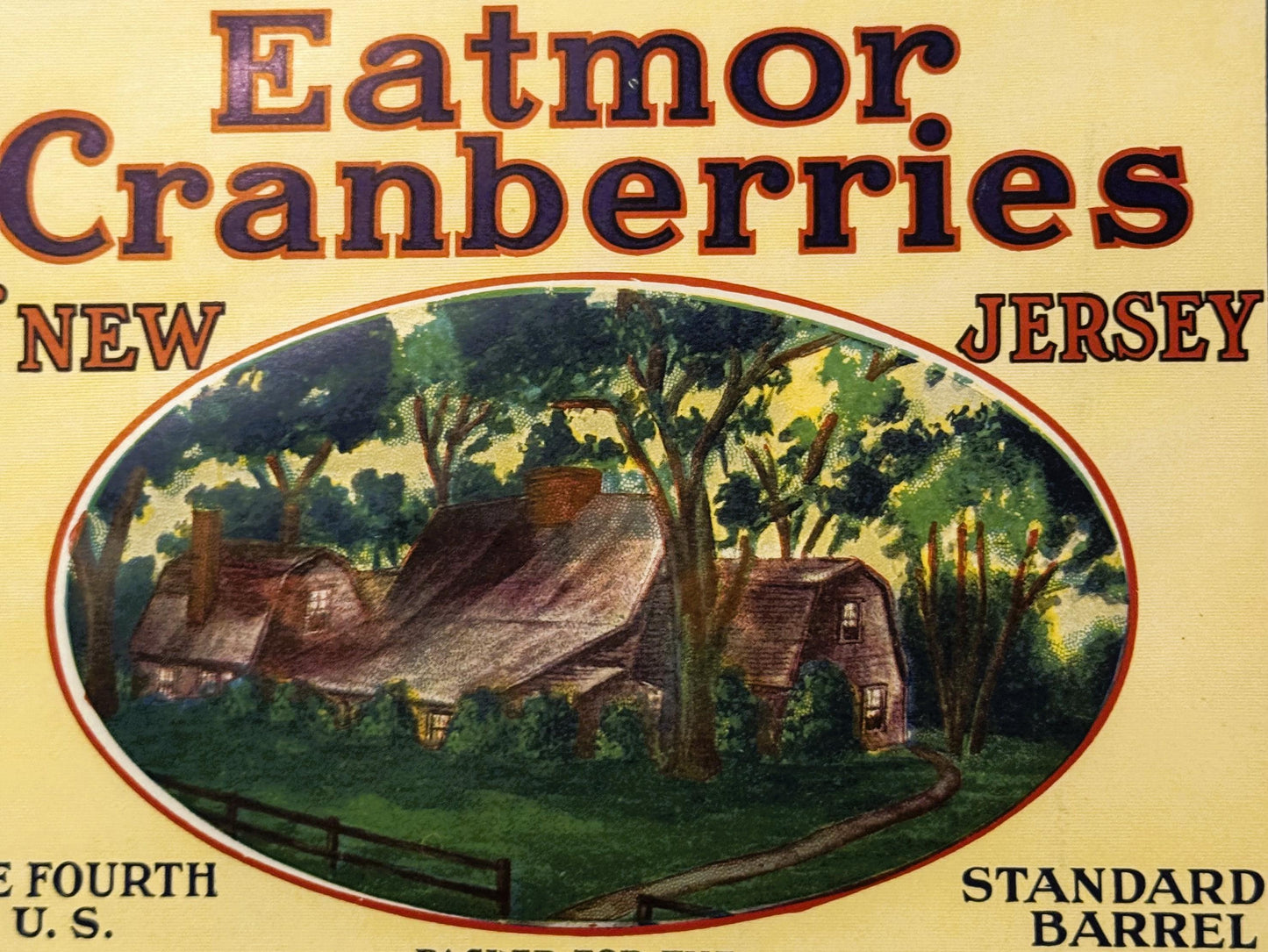 Vintage Eatmor Cranberries barrel label with cream background, red borders, and illustration of thatched-roof homestead surro
