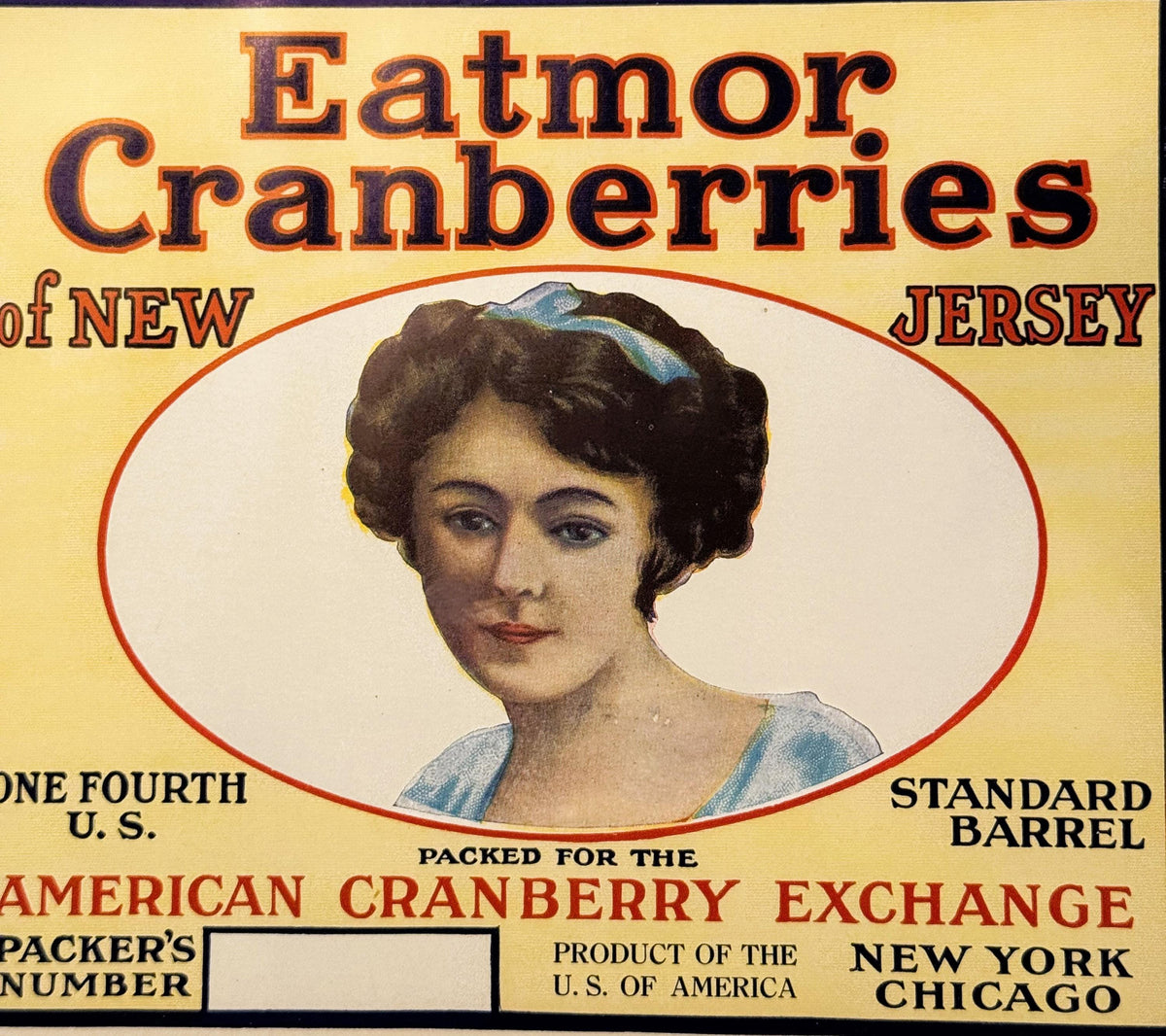 Vintage cranberry barrel label featuring a woman's portrait in oval frame, yellow background, red text reading "Eatmor Cranbe