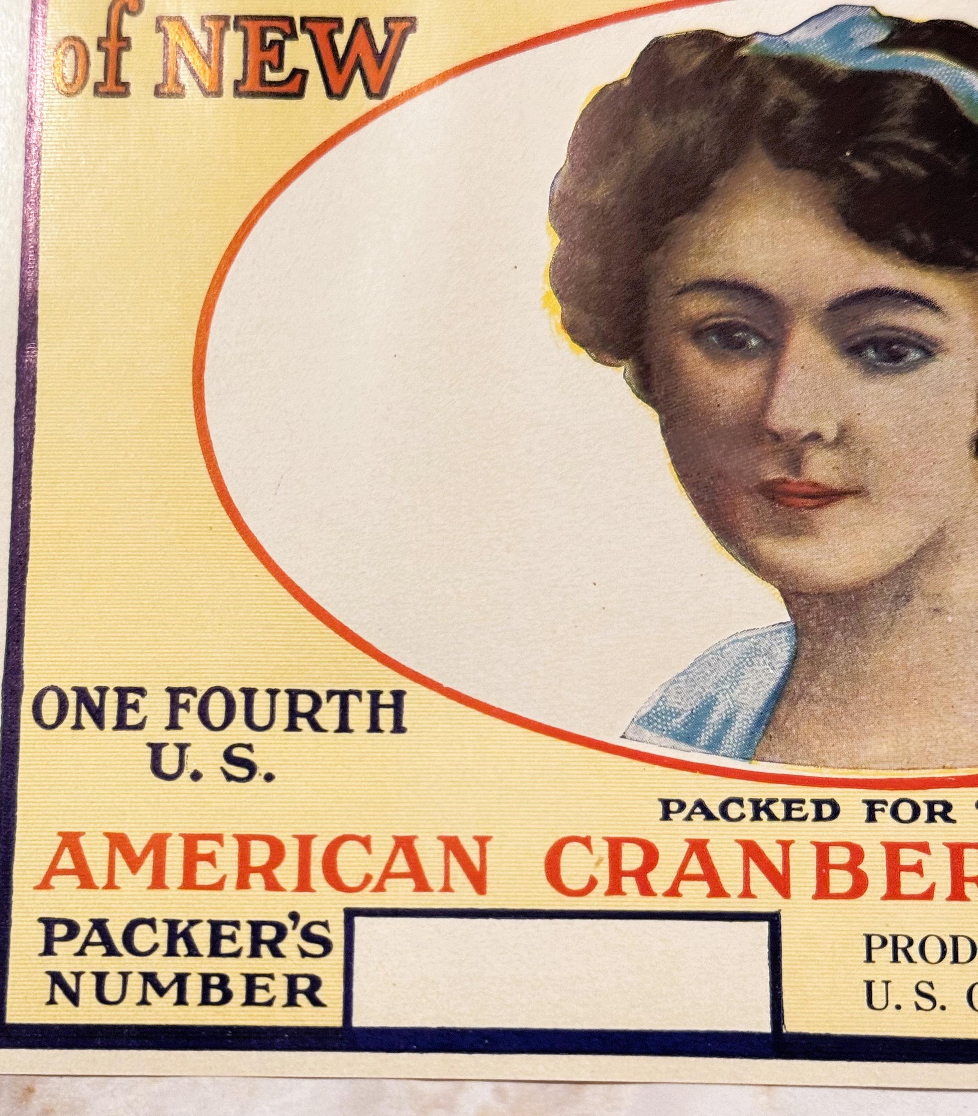 Vintage cranberry barrel label featuring a woman's portrait, yellow background, red curved border, text reading "OF NEW," "ON