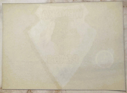 Cream-colored vintage crate label with faint watermark image, showing age spots and wear marks on aged paper