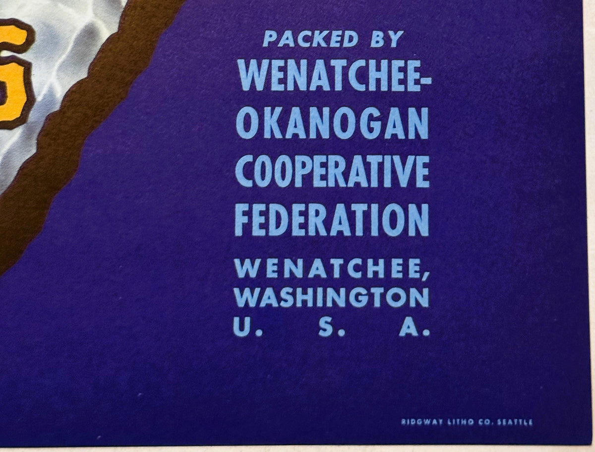 Close-up of blue crate label text reading "Packed by Wenatchee-Okanogan Cooperative Federation, Wenatchee, Washington U.S.A.