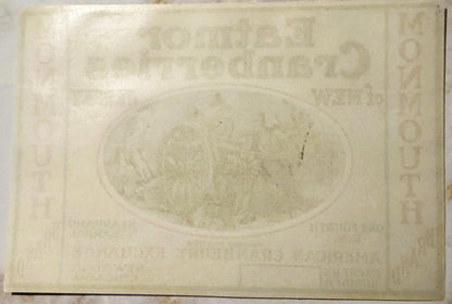 Cream-colored embossed cranberry barrel label featuring oval illustration and text, photographed flat showing wear and age pa