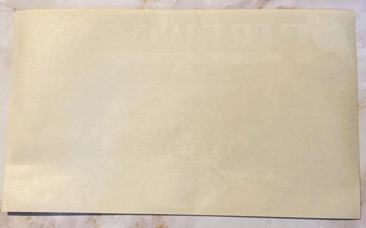 Blank cream-colored vintage crate label with dark border on wooden surface