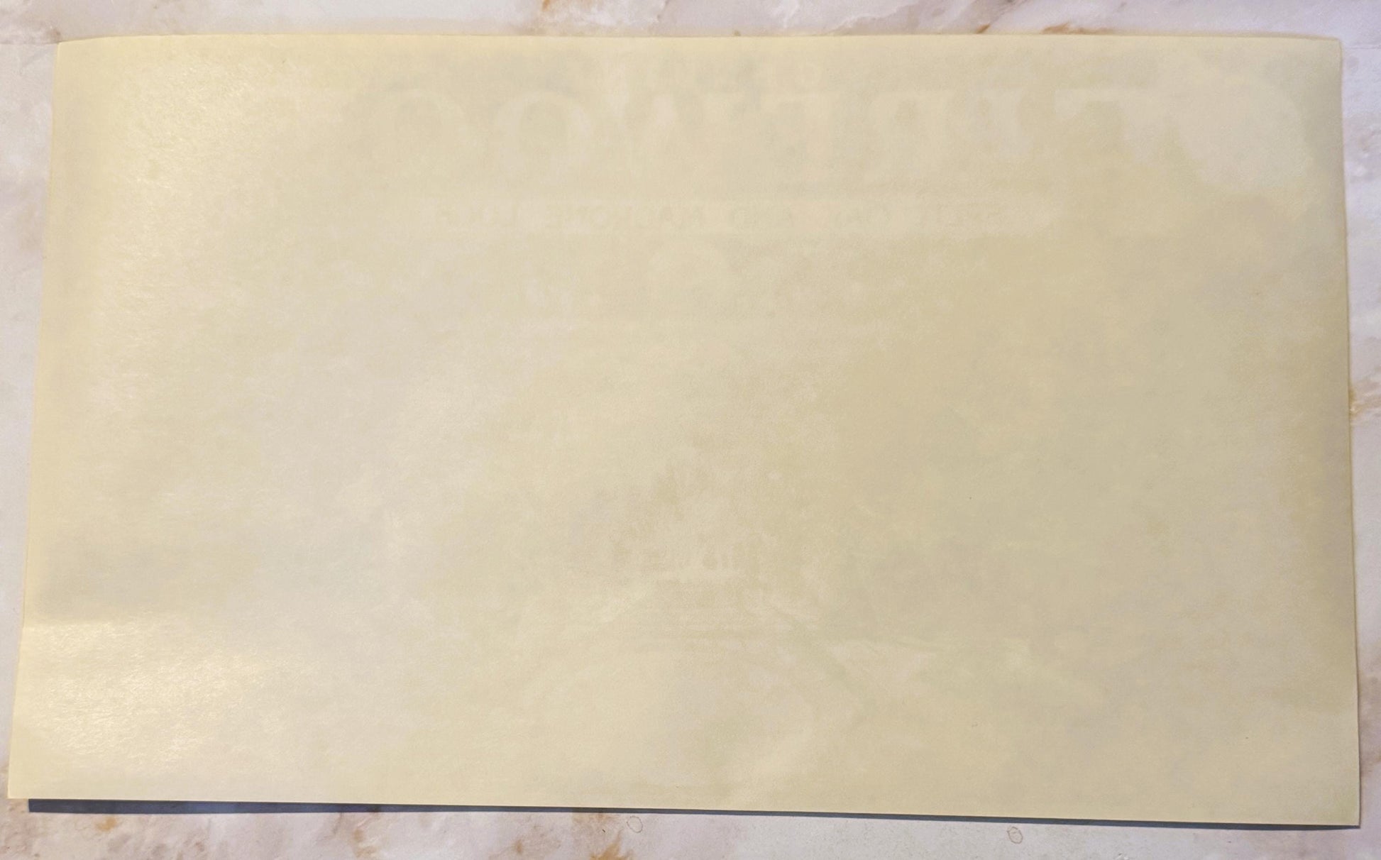 Blank cream-colored vintage crate label with dark border on wooden surface