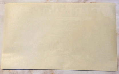 Blank cream-colored vintage crate label with dark border on wooden surface