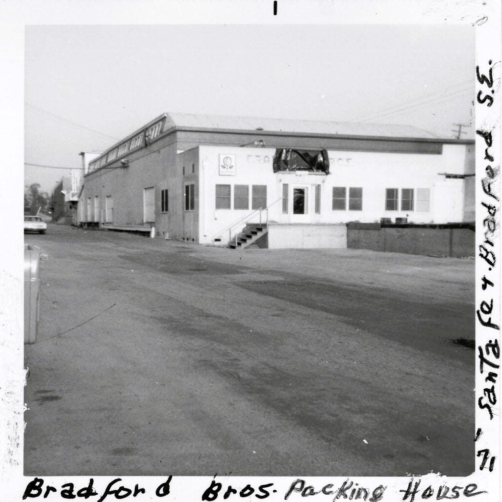 Black and white photograph of Bradford Bros. Packing House exterior, a two-story industrial building with white front section