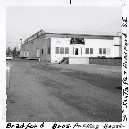 Black and white photograph of Bradford Bros. Packing House exterior, a two-story industrial building with white front section