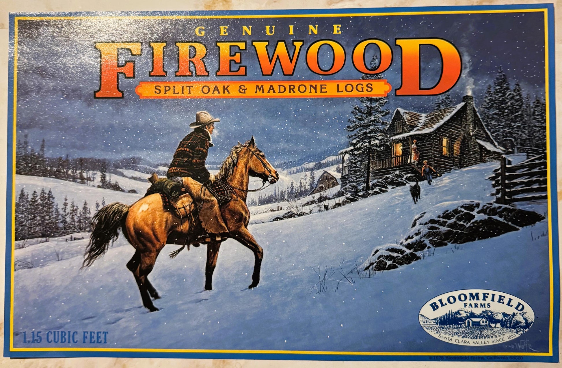 Vintage firewood crate label with cowboy on horseback in snowy landscape approaching log cabin, gold and blue border, Bloomfi
