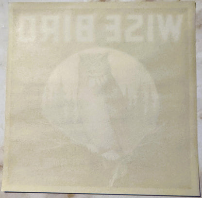 Cream-colored vintage citrus crate label with faded owl illustration and text, shown flat against white background