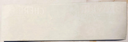 Cream-colored vintage crate label with faint embossed or printed design, dark blue stripe along bottom edge, displayed flat