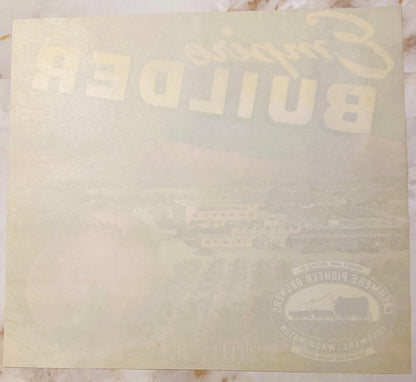 Cream-colored vintage apple crate label with "Empire Builder" text and railroad logo, photographed flat on marble surface
