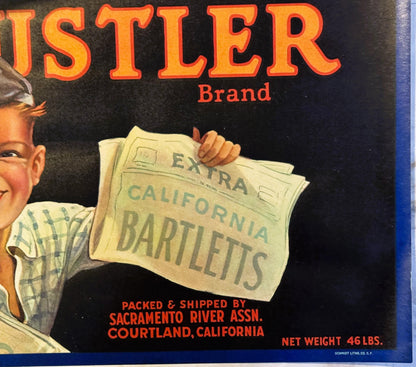 Vintage Hustler Brand fruit crate label with smiling newsboy holding newspaper, orange lettering on black background, Sacrame