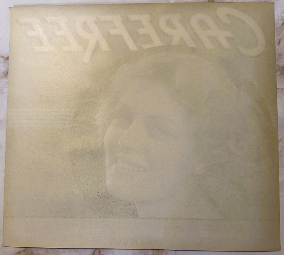 Cream-colored vintage citrus label with embossed "CAREFREE" text at top, displayed flat on marble surface