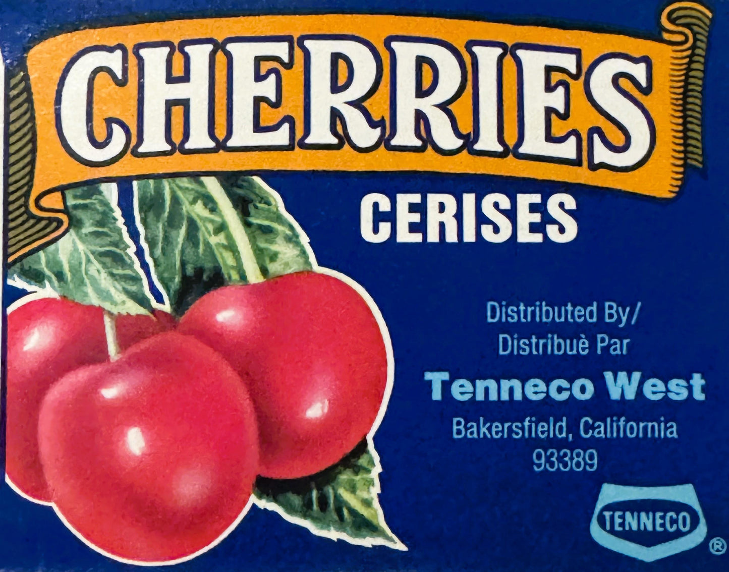 Vintage cherry crate label with red cherries and green leaves on blue background, bilingual English/French text, Tenneco West