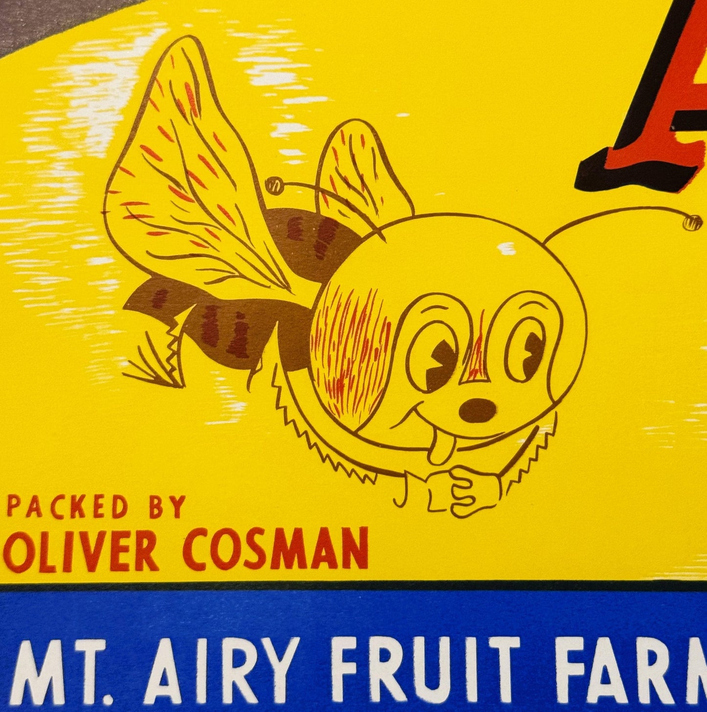 Vintage bee crate label with smiling cartoon bee character, yellow background, red and brown accents, text reading "Packed by