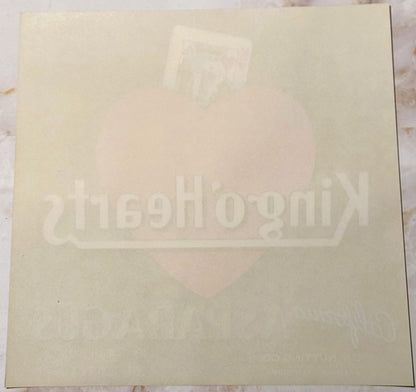 Cream-colored vintage crate label with faint embossed King of Hearts design and text, photographed flat against white backgro