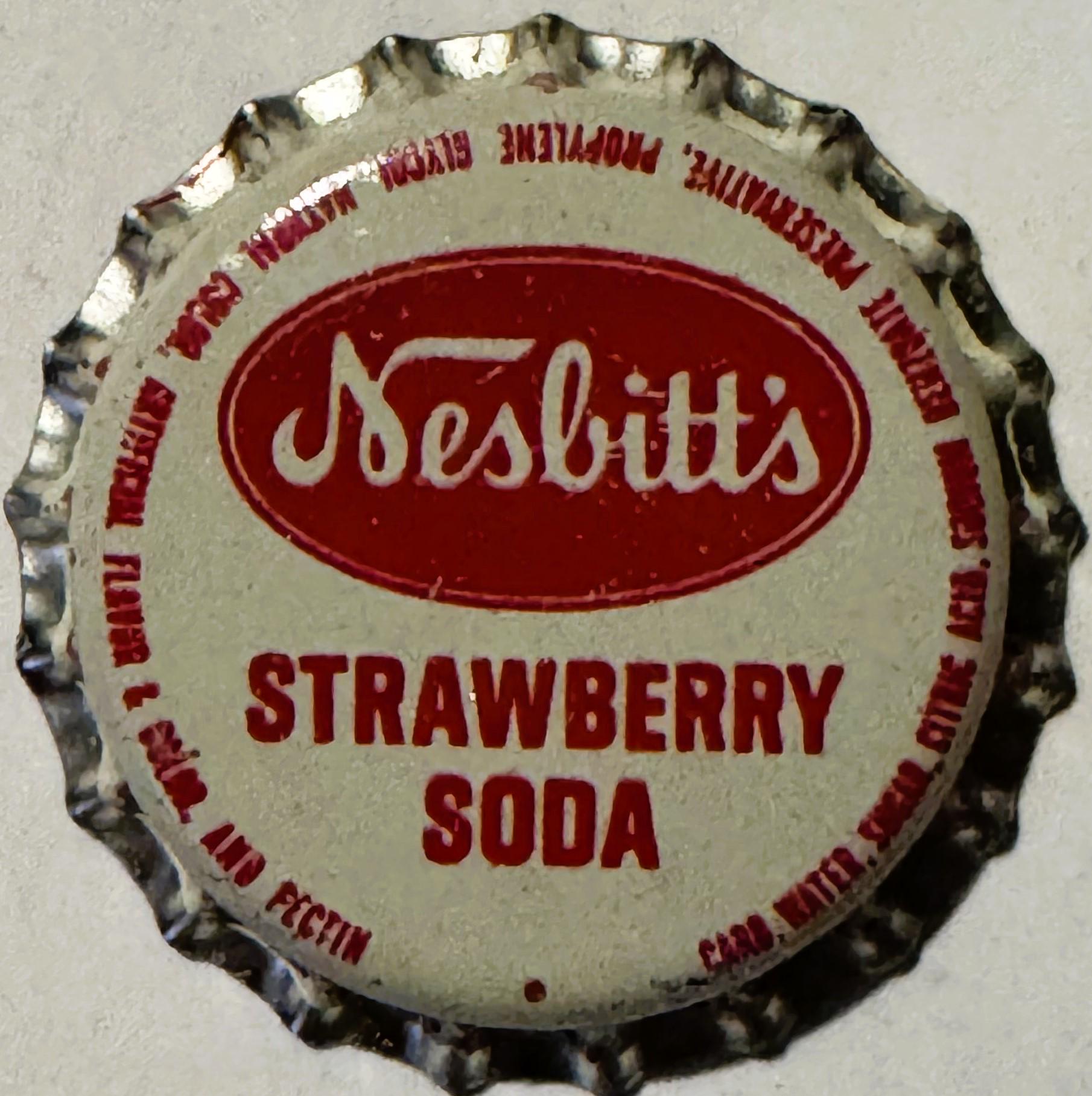 Vintage Nesbitt's Strawberry Soda bottle cap with red and cream colors, shown flat against gray background