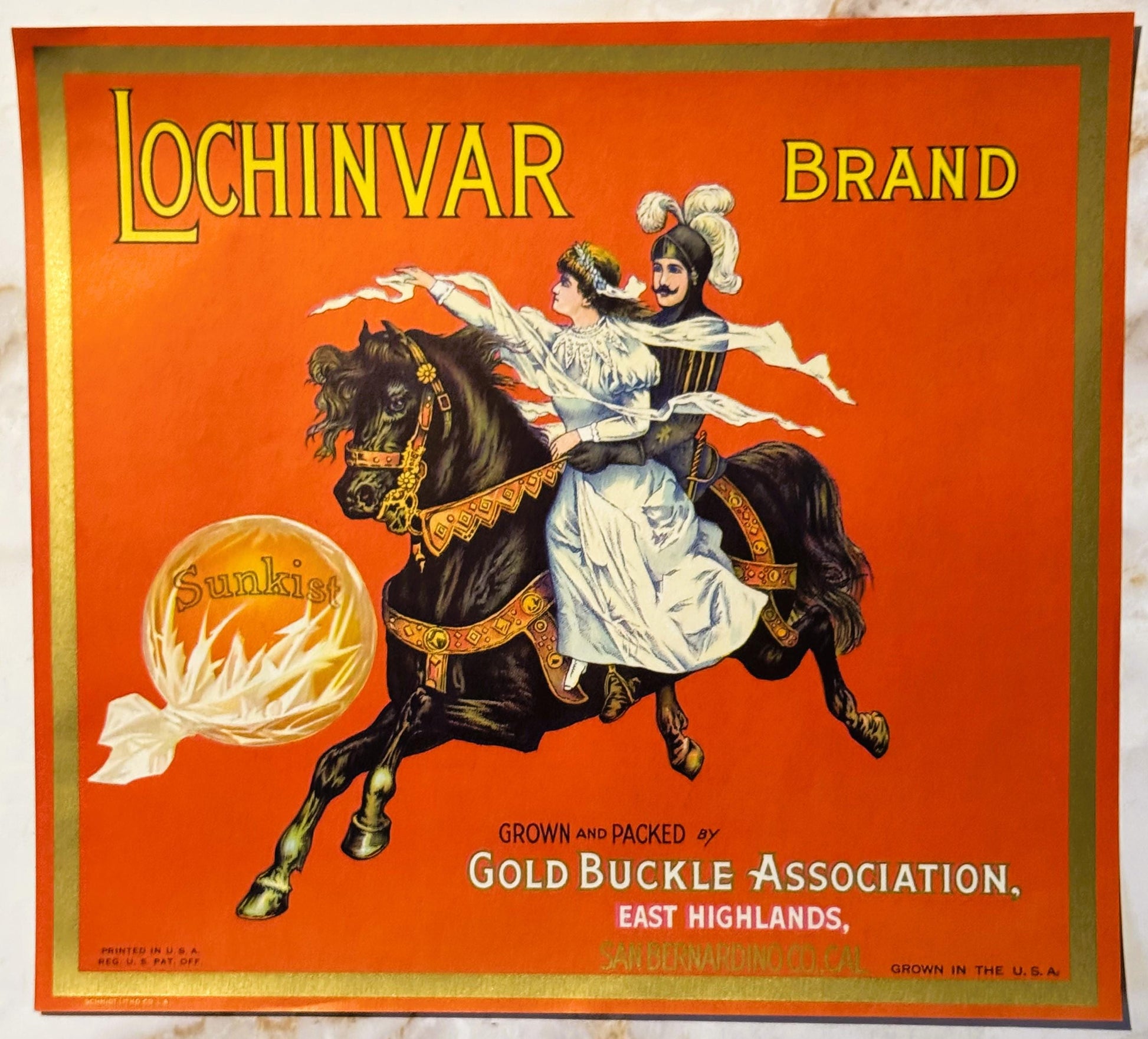 Vintage orange crate label featuring two figures on a galloping horse, with "Lochinvar Brand" text and Gold Buckle Associatio