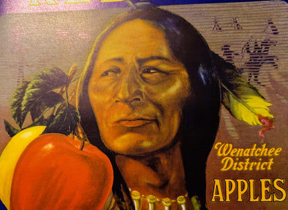 Vintage Wenatchee District Apples crate label featuring portrait of Native American man with long dark hair and red apple, ye