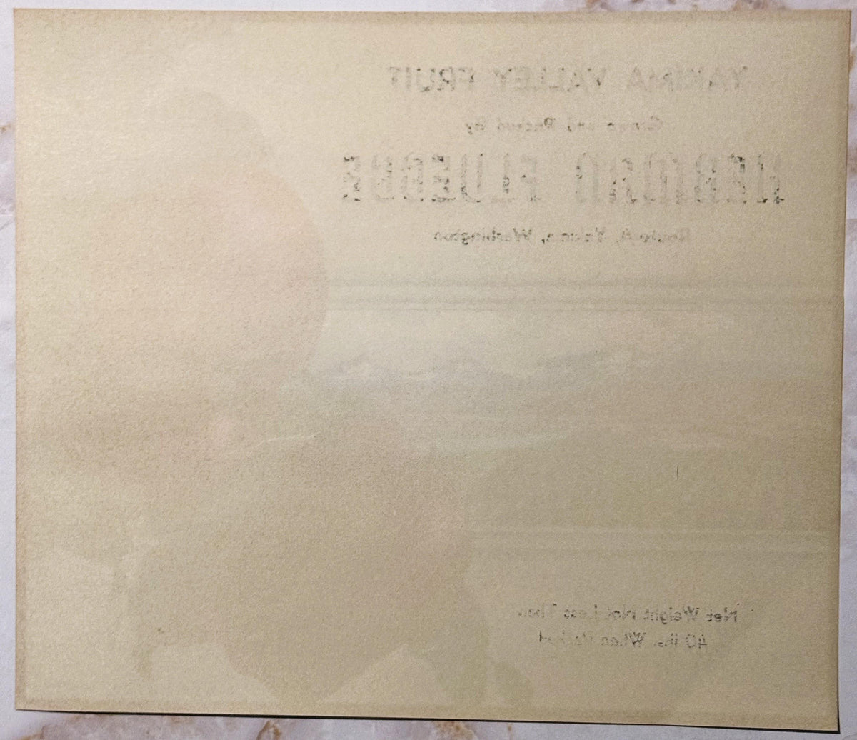 Aged cream-colored fruit crate label with faint typewritten text, photographed flat showing wear and discoloration