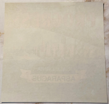 Cream-colored vintage crate label with faint embossed text, shown flat against white surface with dark border line visible at