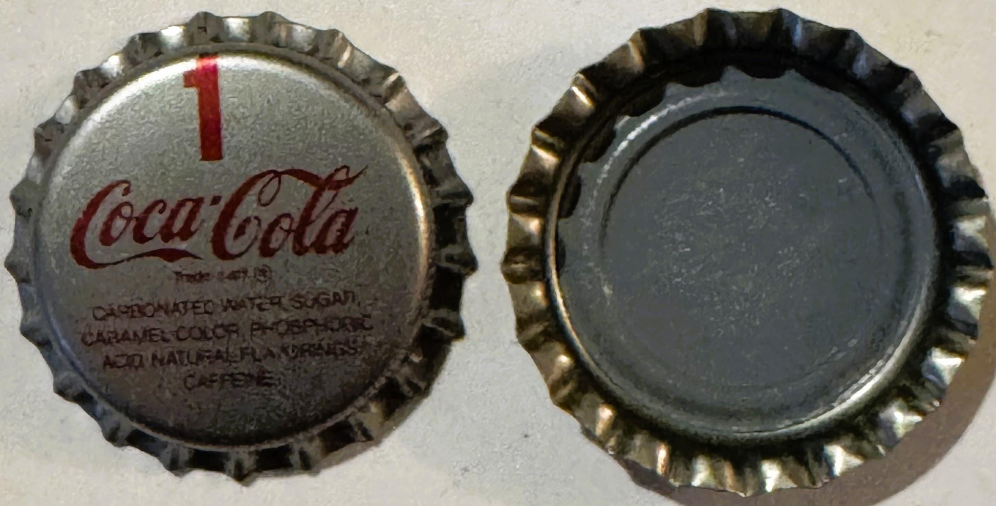 Vintage Coca-Cola bottle cap with red swirl logo and ingredients text, shown front and back views against white background