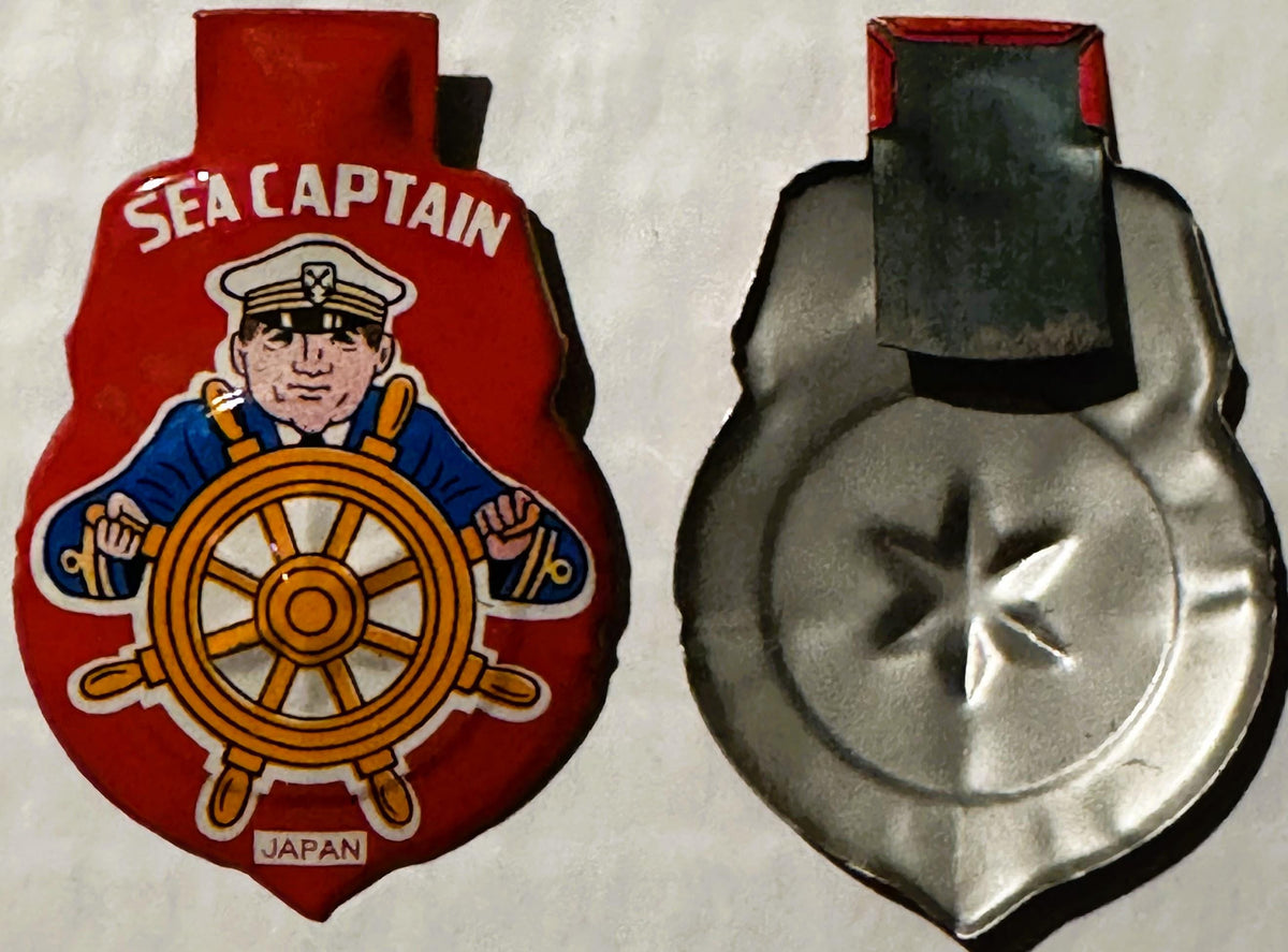 Front and back of vintage red tin litho Sea Captain clicker toy showing sailor at ship's wheel, made in Japan