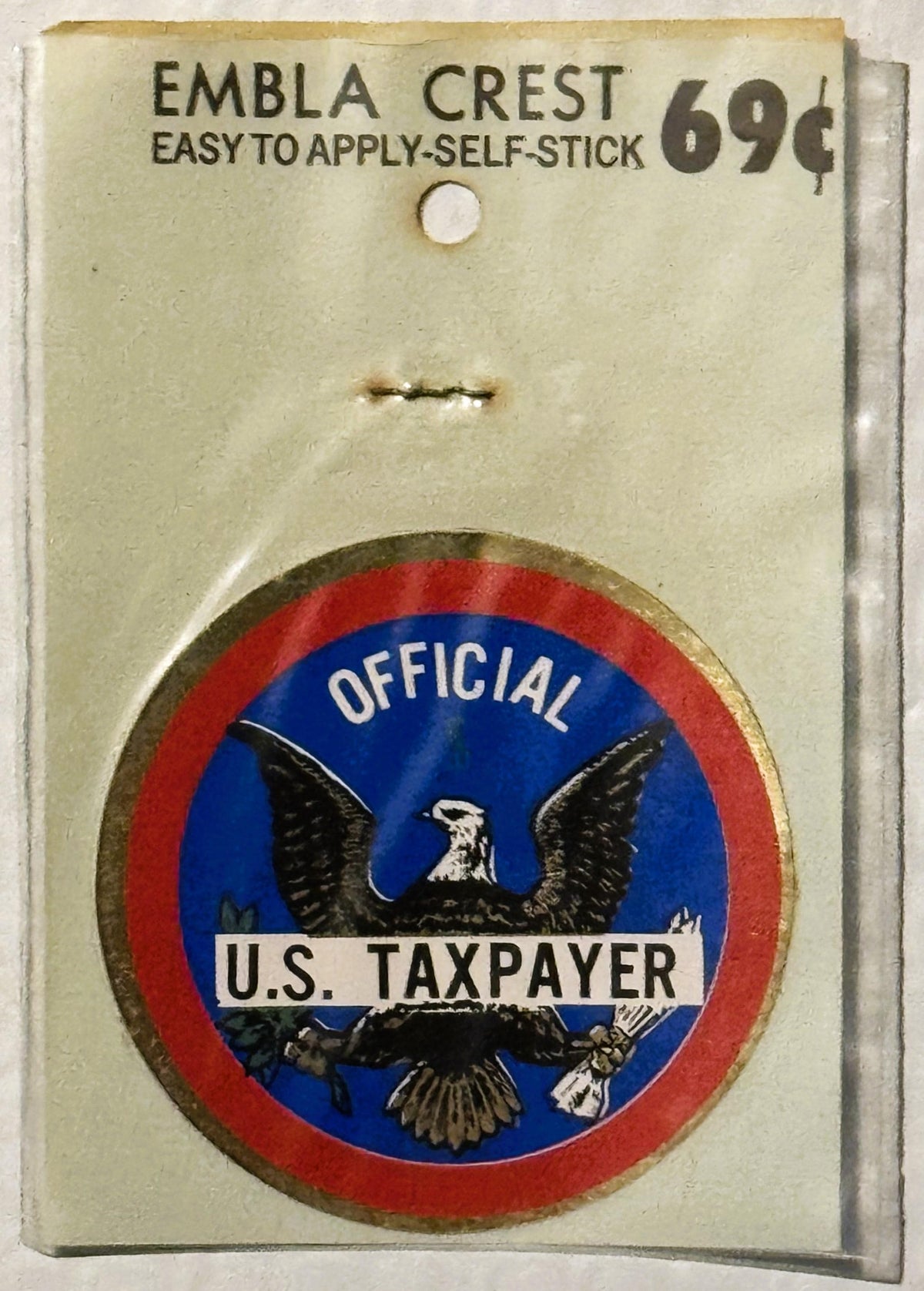 Vintage self-stick emblem crest featuring blue circle with black eagle, red outer ring, and white "Official U.S. Taxpayer" ba