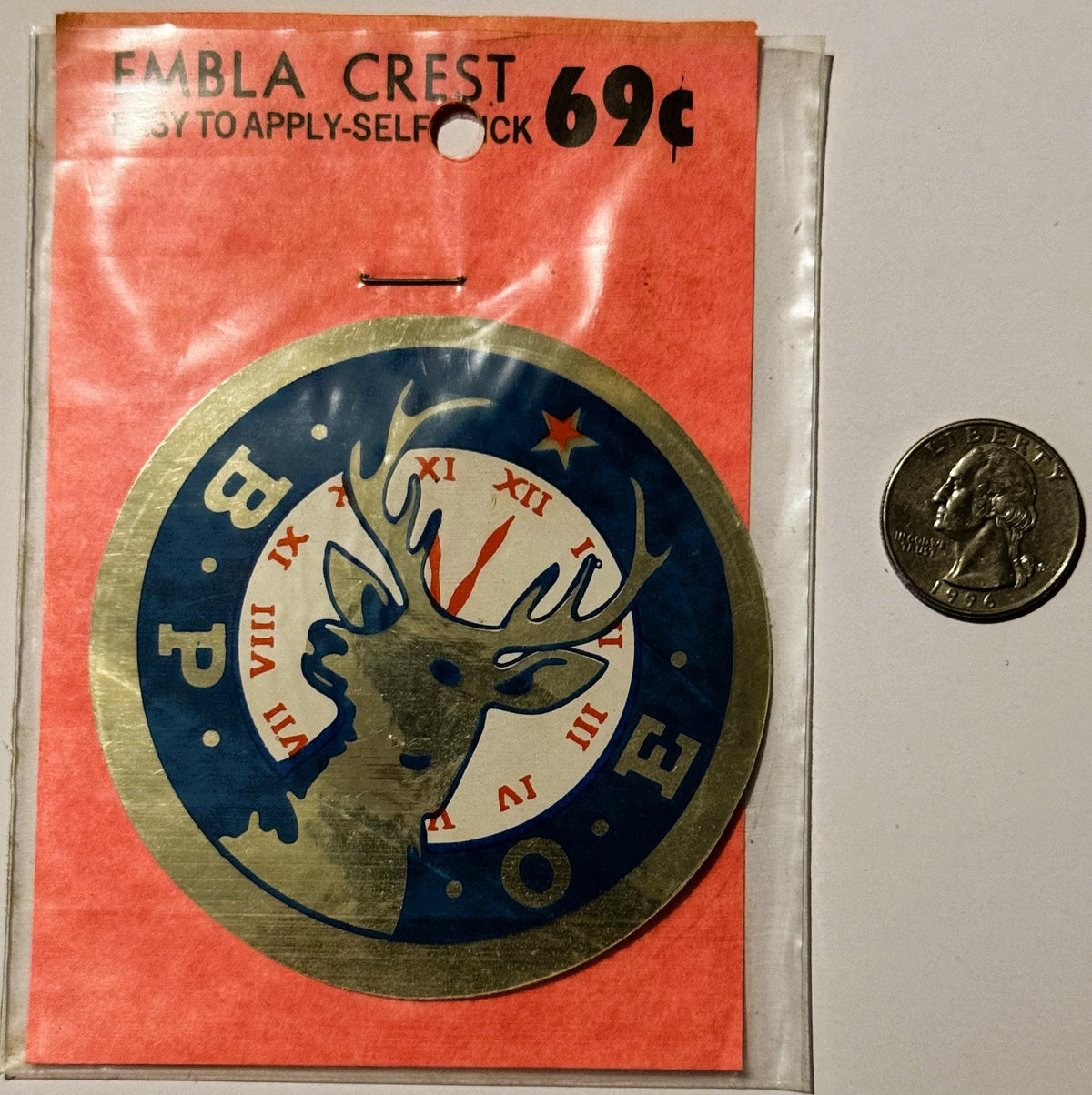 Vintage BPOE Elks emblem decal on red packaging with quarter coin for scale, showing deer head with antlers in blue and cream