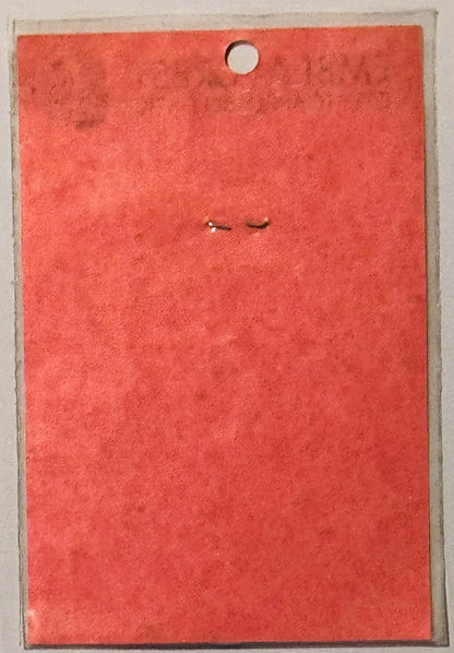 Bright red vintage decal with hole punch at top, displayed against tan cardboard backing, showing minimal visible text or ima