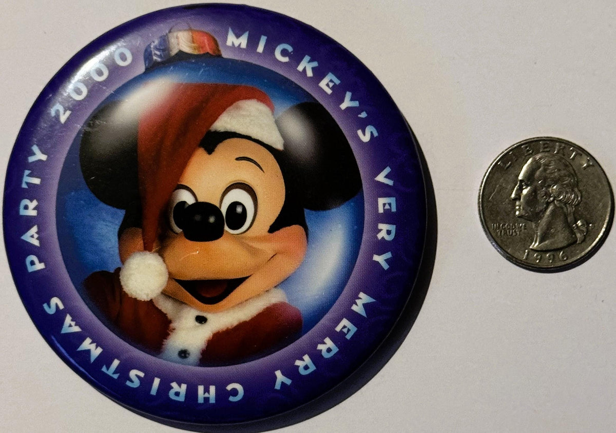 Circular purple pin featuring Mickey Mouse in Santa hat, with quarter coin for scale, text reading "2000" and "Mickey's Very 