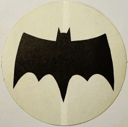 Black bat silhouette with pointed ears on cream circular background, vintage sticker or decal